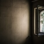 Una finestra aperta fa entrare della luce in una stanza scura